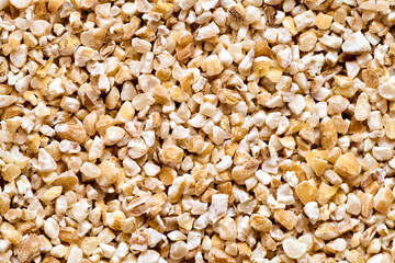 Raw dried broken barley cereal grain texture background macro closeup. Barley groats coarse barley semolina. Concept of healthy eating protein diet and vegetarianism.