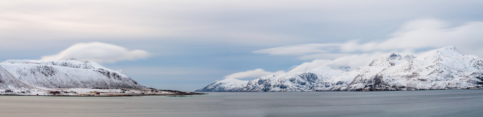 Long exposure image of a winter landscape in panorama with snow covered mountains and fjord on the Lofoten in northern Norway