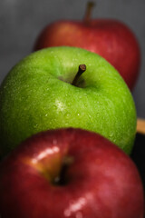 green and red apple in a row vertically on