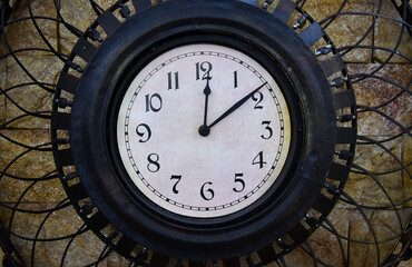 Metal rustic clock showing 12.09 o'clock