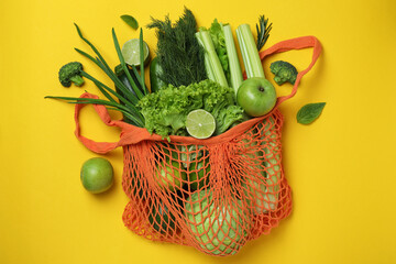 String bag with green vegetables on yellow background