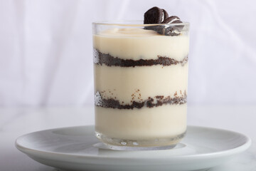 Delicious magnolia, oreo, piece of chocolate in glass coffee on white