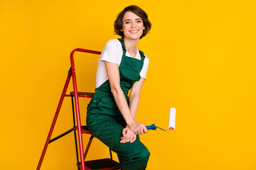 Photo of happy cheerful girl painter sit ladder relaxing from work holding roller break pause...
