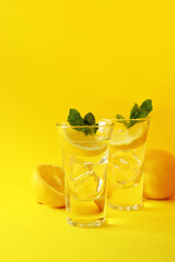 Shots with lemon slice and mint on yellow background