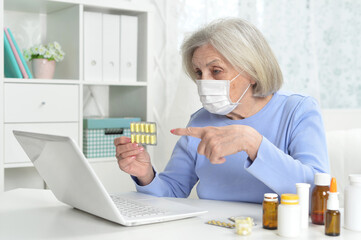 ill beautiful senior woman  with facial mask holding pills