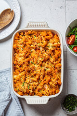 Baked pasta with chicken and cheese in oven dish, gray background, top view. Italian cuisine...