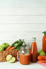Apple - carrot juice and ingredients on white wooden background