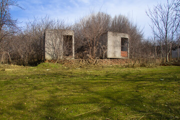 Obraz premium Ruins of an abandoned concrete house overgrown with trees in a forest in southern Russia, Krasnodar