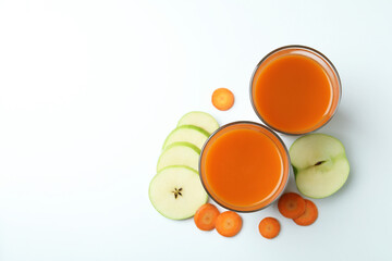 Glasses with juice and ingredients on white background
