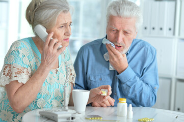 Sick senior couple calling to doctor