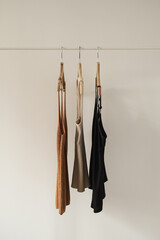 Women's fashion bright pastel clothes on clothing rack on white background. Minimalist fashion blog concept.