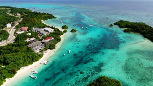 石垣島川平湾でコバルトブルーに輝く珊瑚の海を進む遊覧船を空撮