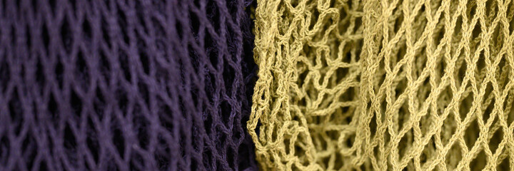reusable shopping mesh bags purple and yellow colors close up. banner