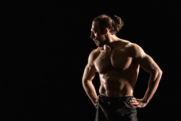 Fototapeta na wymiar Portrait of athletic man on black background
