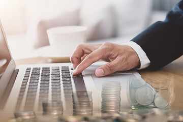 Double exposure of young business man in a suit is using a computer to search for find financial information and calculate the costs and expenses of investing in their business for future.