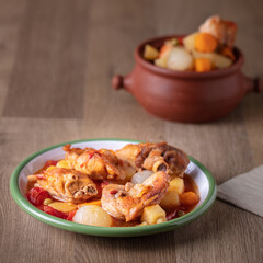 Stewed Chicken with vegetables on wooden table