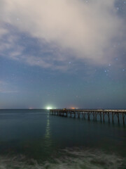 Fototapeta na wymiar Night view of a pier in the ocean.