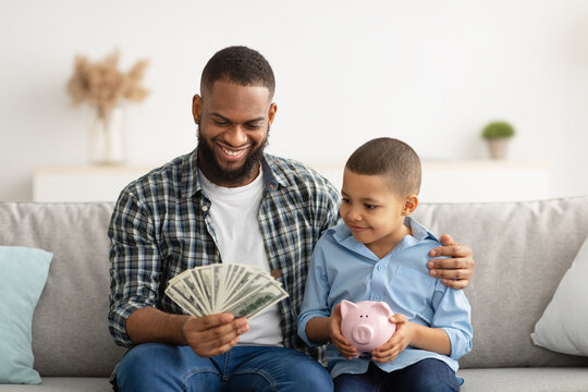 Dad Holding Money Talking With Son About Personal Savings Indoor