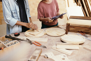 Fototapeta na wymiar Team of carpenters making round wooden cutting boards for customer