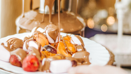 A marshmallow that has just been freshly dipped in warm milk chocolate fondue. Shot on white background.