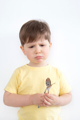 Sad boy holding a spoon and a fork