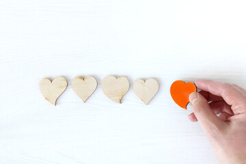 red painted heart symbol in hand and colorless wooden. regular and anniversary follower