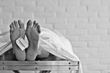 concept imitation morgue, coronavirus victim killed by 2019-ncov, legs of a corpse on a table, man...