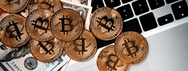 Bitcoin. Business top view design concept with USD Dollar paper currency on laptop.