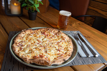 Pizza with beer and wooden background