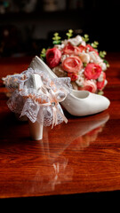 White female shoes and a garter of the bride on a brown background. Wedding accessories for the bride