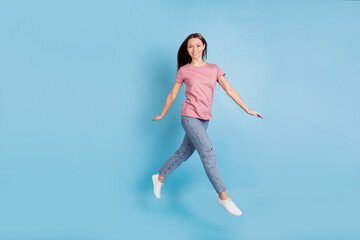 Fototapeta na wymiar Full length profile side photo of charming happy positive girl jump up walk empty space isolated on blue color background