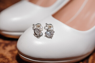 Wedding accessories for the bride. White shoes, earrings