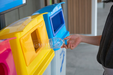 A plastic bottle is disposed of in a trash can. Sort in a garbage container. Concept pollution of the environment, environmental protection.