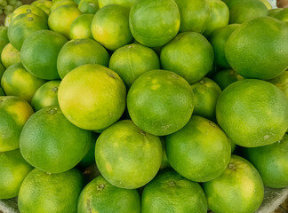 Green oranges on the market to buy, Thai oranges are among the juiciest of oranges with a yellowish-green peel and bright orange flesh