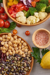 Healthy vegan lunch bowl, buddha bowl salad with ingredients. chickpeas, various nuts and tomatoes, broccoli, carrots . Healthy balanced vegetarian food concept. Top view.