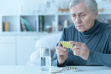 Sick senior woman taking medicine