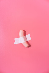 Boiled sausage with white tape to a pink background. Creative fun concept in the style of minimalism.