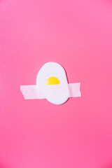 Scrambled eggs are glued with white tape to a pink background. Creative fun concept in the style of minimalism. - 428803682