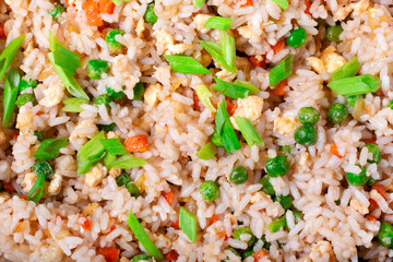 Fried rice with vegetables and egg. Hot meal texture. Full frame