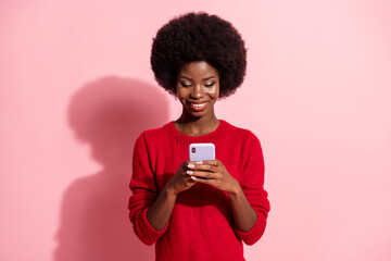 Portrait of attractive cheerful focused girl using device app 5g comment isolated over pink pastel color background