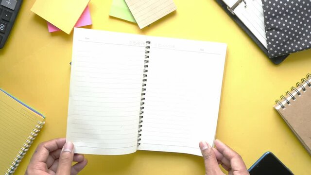 man's hand turning a pager of a diary 