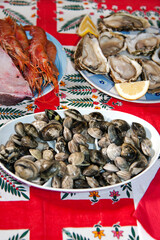 Dishes with Italian vongole [clams], with oysters, and with grilled king prawns together slices of fresh tuna.