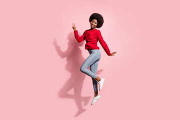 Fototapeta na wymiar Full length body size view of attractive cheerful girl jumping showing v-sign having fun isolated over pink pastel color background