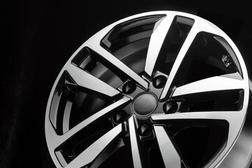 new shiny alloy wheel on black background, close-up details