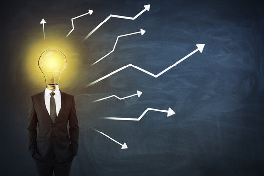 Creative idea and business concept with man in black suit with light bilb on shoulders on blackboard with arrows background