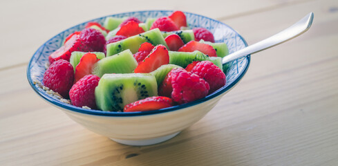 Breakfast fruit bowl with strawberries and kiwis, close up. Healthy lifestyle for vegetarians.