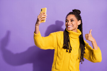 Photo of optimistic nice brunette girl do selfie show thumb up wear sweater isolated on purple...