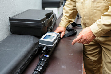 Radiation detector testing. Dosimetrist hands adjusting a portable gamma radiation dosimeter set on...