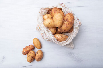 Raw fresh organic potatoes. Full bag of potatoes. Burlap sack with potatoes. Space for text