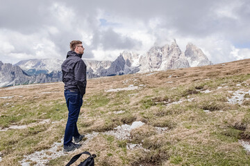 Young man traveller hiking in Dolomite Alps mountains.